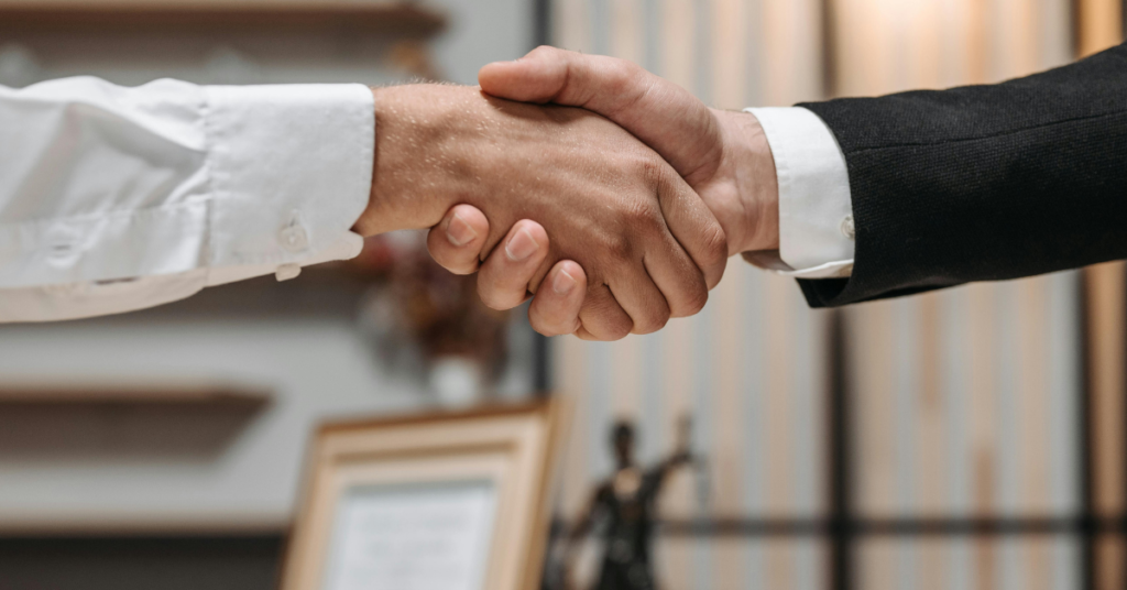 Close up of two hands shaking to represent meeting with a lawyer. 