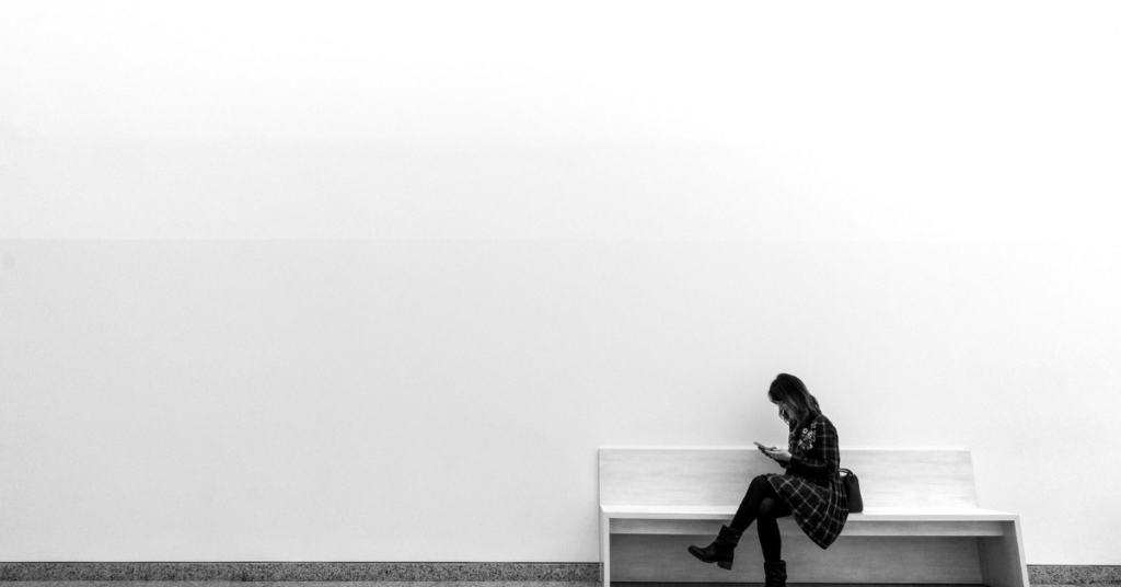 Women sitting on bench against white wall to represent limited market appeal or niche markets causing startups to fail. 