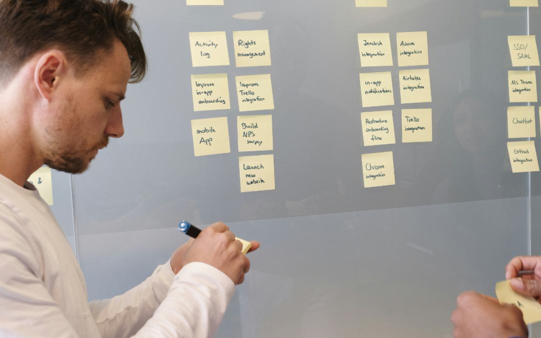 Two men planning with sticky notes on a board to represent the content of the post covering what to do when an investor passes on your startup.